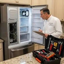 Technician inspecting an open refrigerator beside a professional tool case